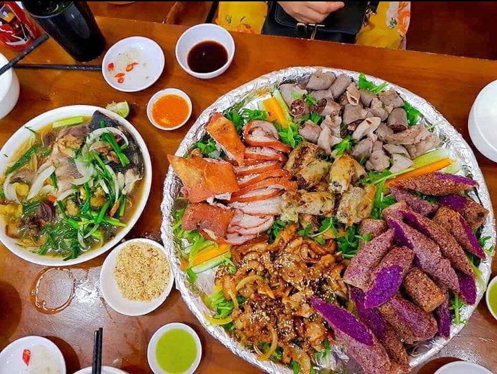 A platter of grilled Sapa specialities including sliced pork, crispy pork belly and offal with greens and dipping sauces