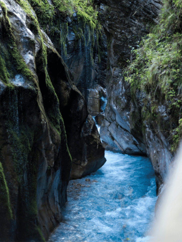 A turquoise river rushing through the moss-covered marble walls of Taroko Gorge in Taiwan