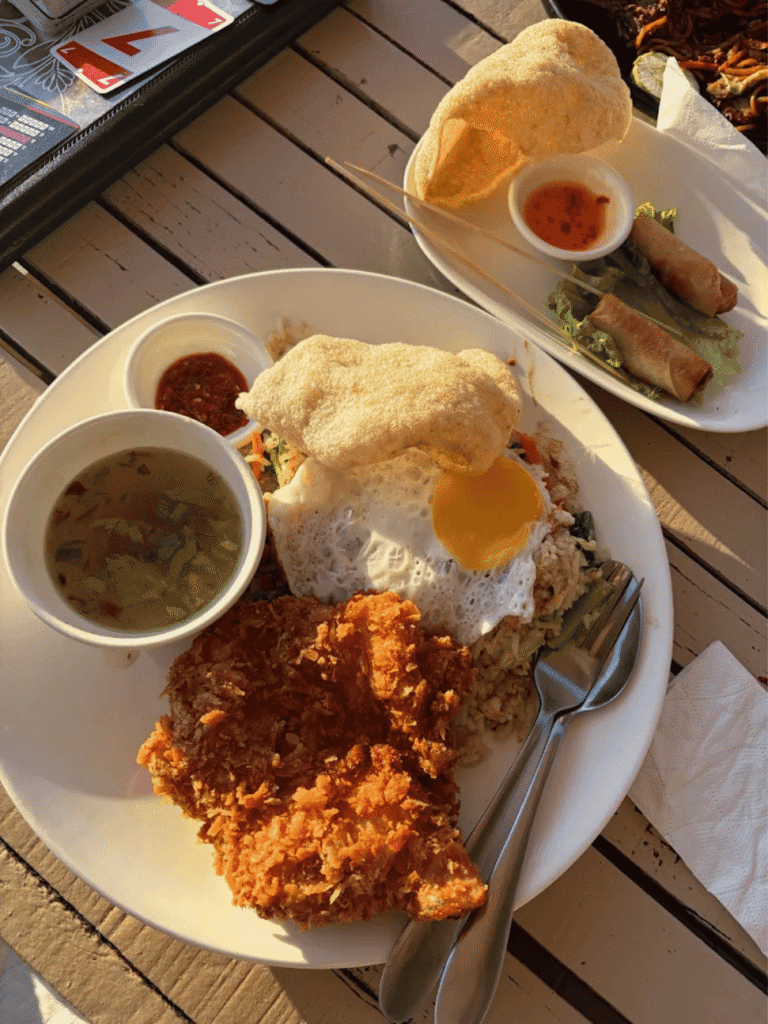 A plate of rice with fried egg, crispy chicken and prawn crackers, with soup and spring rolls, at Rosemary Cafe