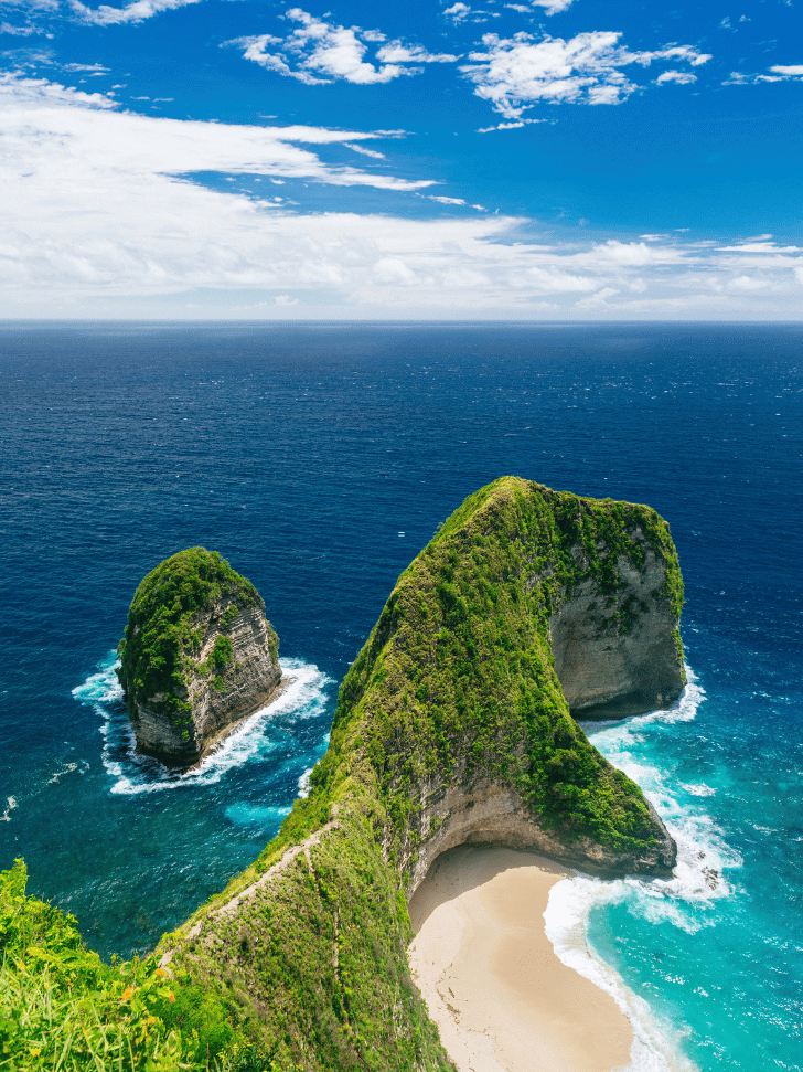 Kelingking Beach's T-Rex-shaped cliff and cove from the clifftop, deep blue sea beyond