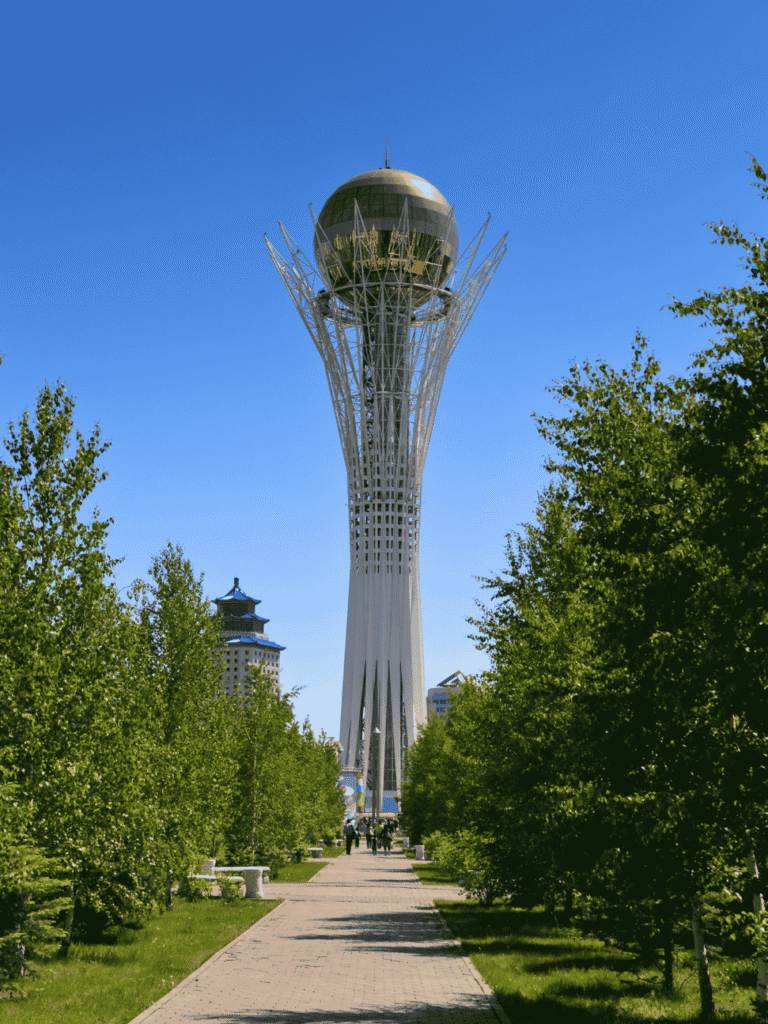 Astana's Bayterek Tower with its golden sphere above a tree-lined path