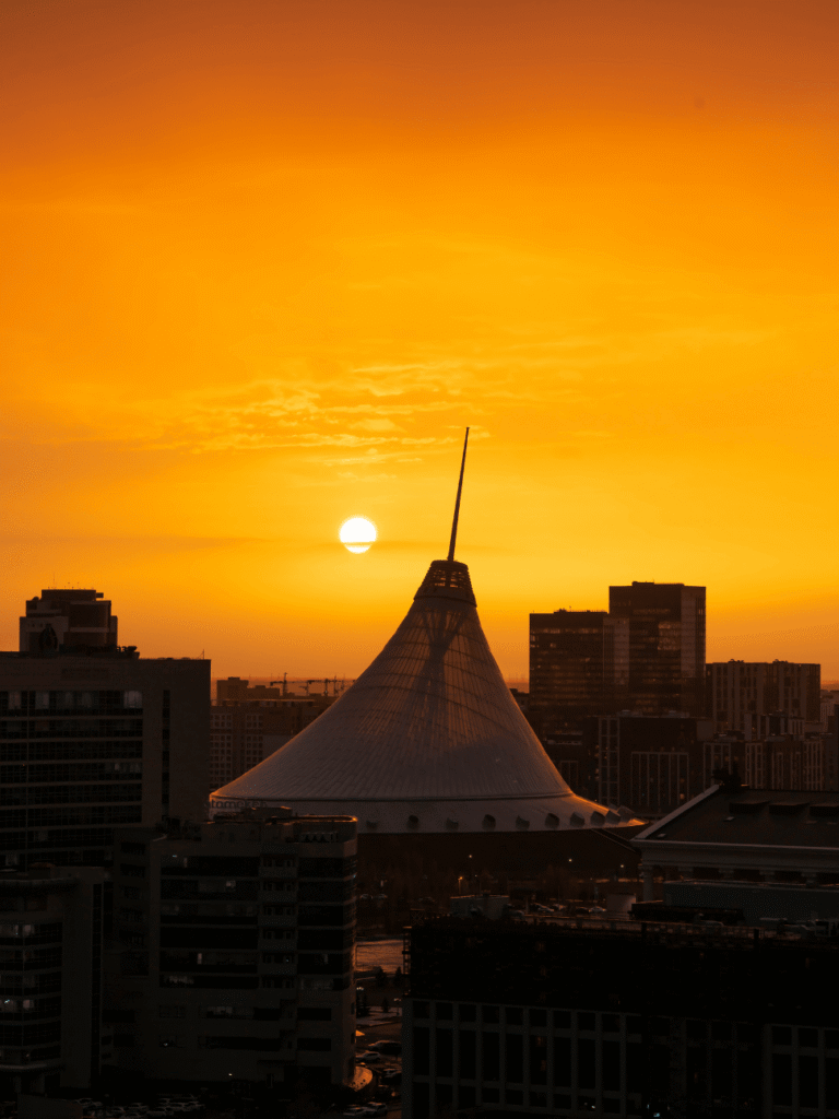 The tent-shaped Khan Shatyr silhouetted against an orange Astana sunset