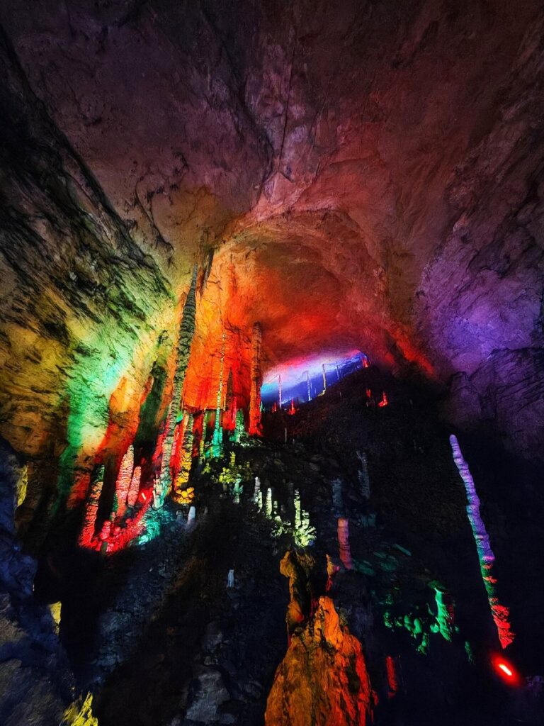 Multicolour-lit stalactites and stalagmites inside Yellow Dragon Cave