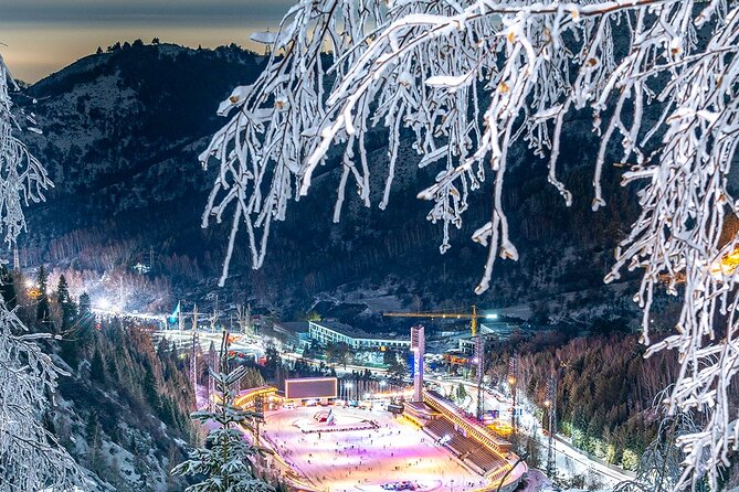 The floodlit Medeu skating rink in a snowy mountain valley at night