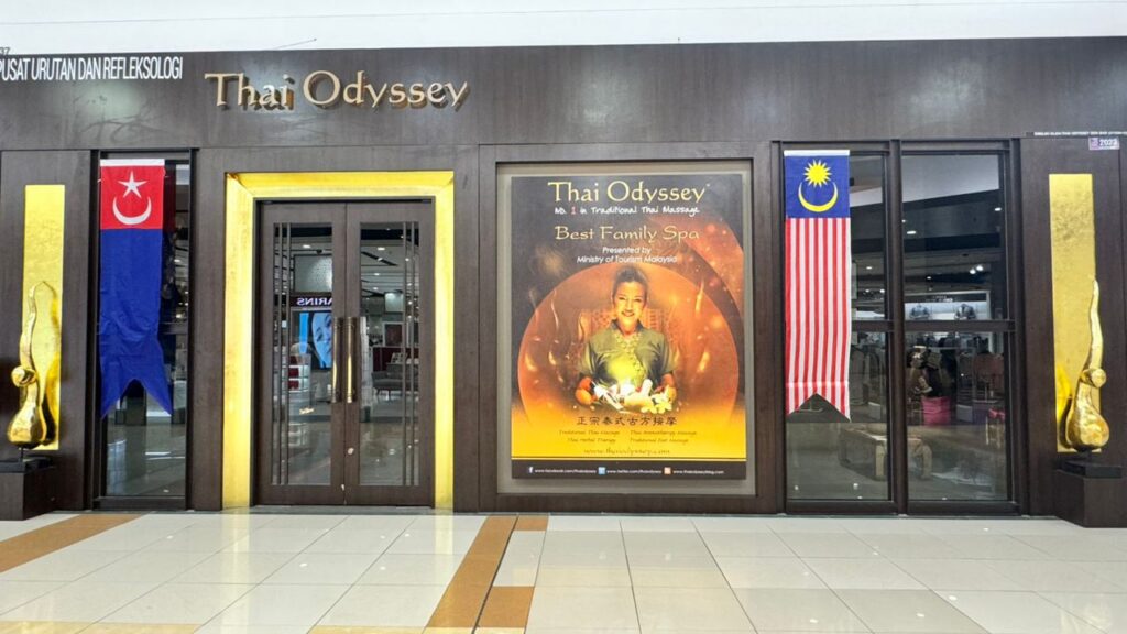 Thai Odyssey spa storefront with gold signage and a Best Family Spa poster