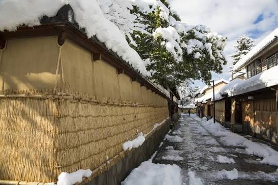 Snow-topped earthen wall lining a lane in Kanazawa's Nagamachi samurai district
