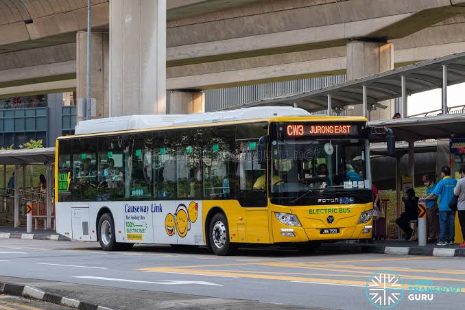 A yellow Causeway Link CW3 bus to Jurong East waiting at a covered bus bay