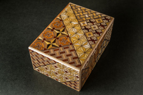 A wooden Hakone yosegi-zaiku box with intricate geometric marquetry patterns
