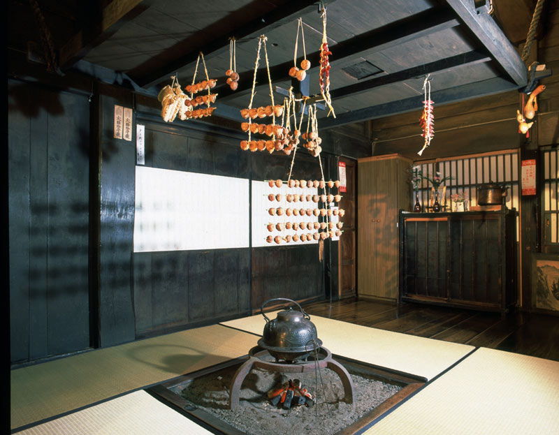 Dried persimmons and chillies hanging above an irori hearth inside a gassho-zukuri farmhouse