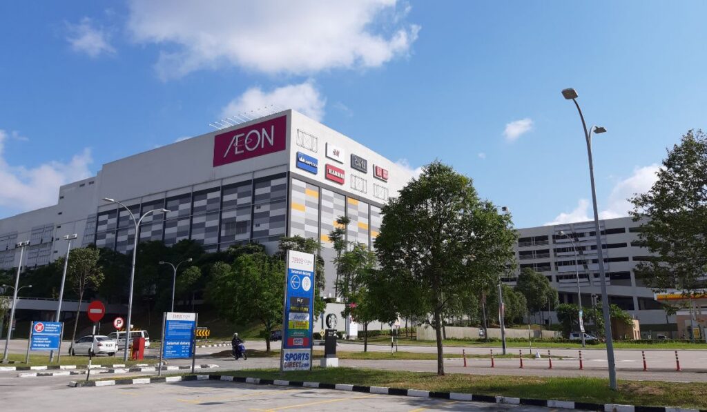 AEON Mall Tebrau City's multi-storey facade lined with retail brand logos under a blue sky