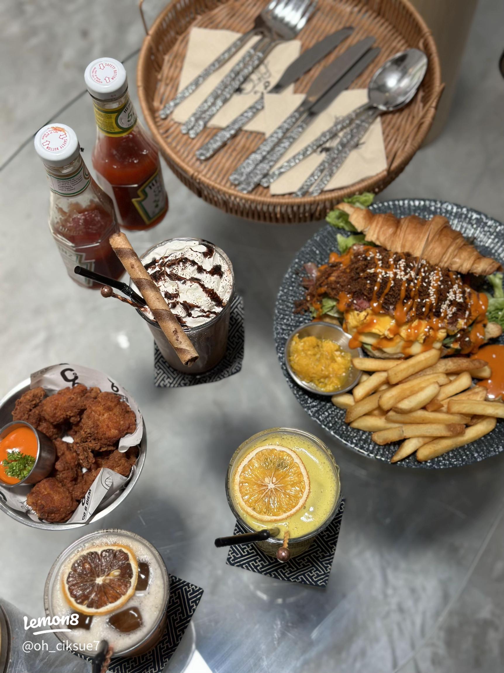 Cafe brunch of a croissant burger, fries, fried chicken and iced drinks in Kuah, Langkawi