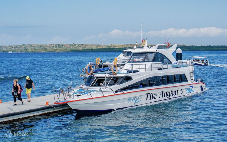 Passengers boarding a fast boat at a jetty for the crossing to Nusa Penida