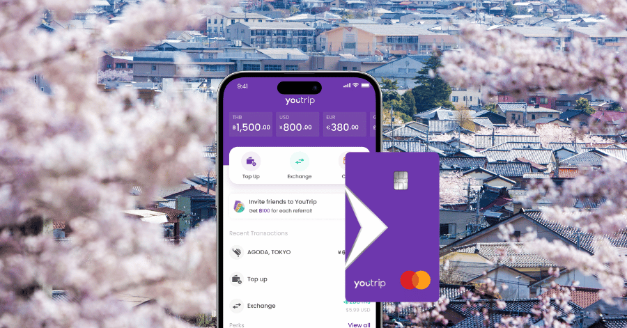 The YouTrip app and purple card shown over a Japanese townscape with cherry blossoms