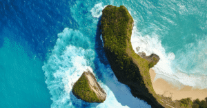 Aerial view of Kelingking Beach's T-Rex-shaped headland and white-sand cove, Nusa Penida