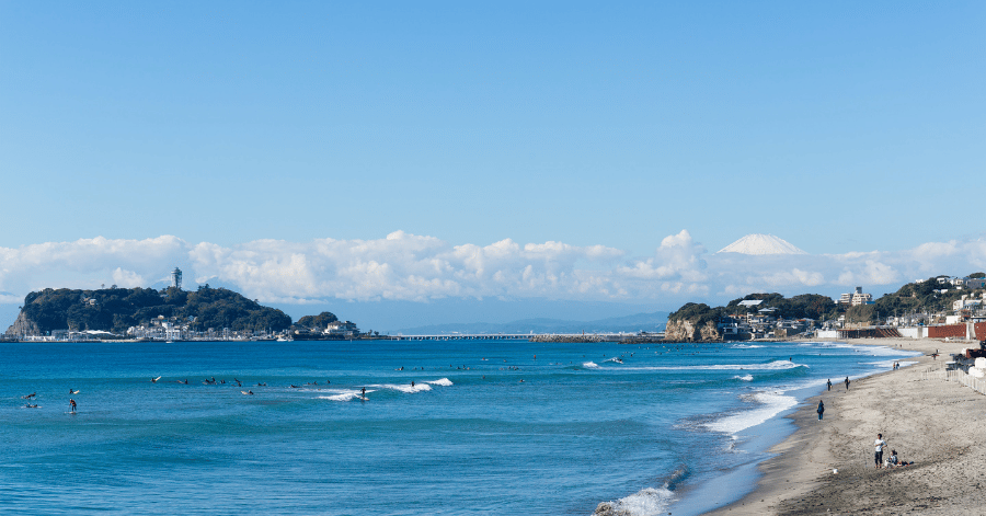 Surfers off Kamakura's Shonan coast with Enoshima island and Mt Fuji on the horizon