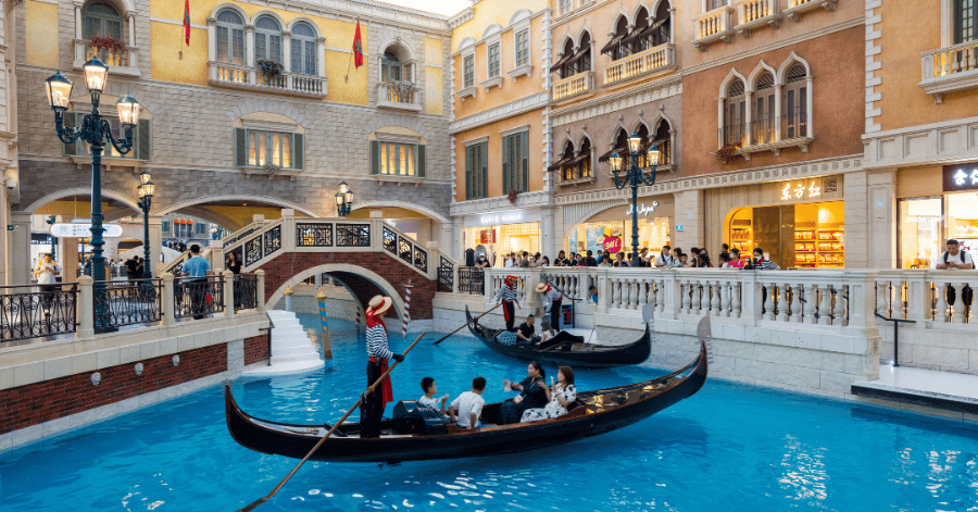 Gondoliers steering gondolas along the indoor Grand Canal at The Venetian Macau