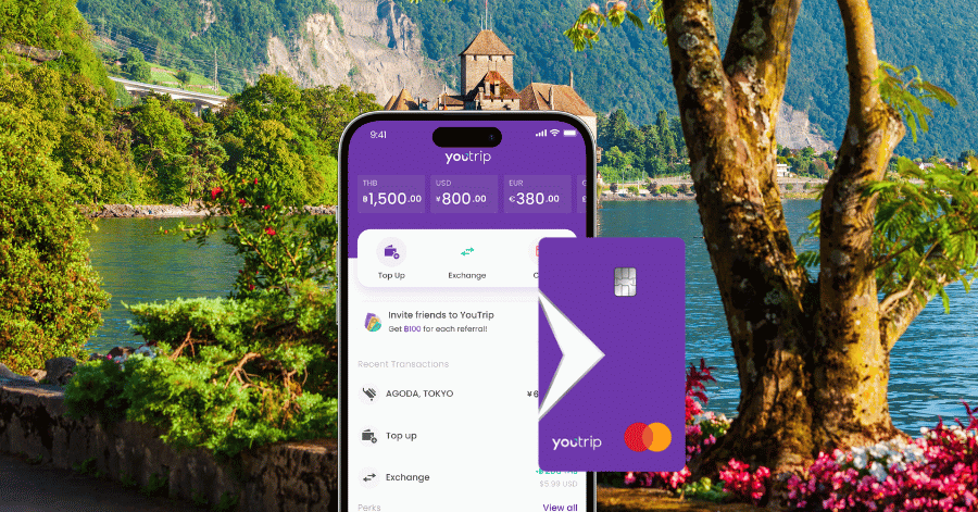 The YouTrip app and purple card shown over a Swiss lakeside castle backdrop