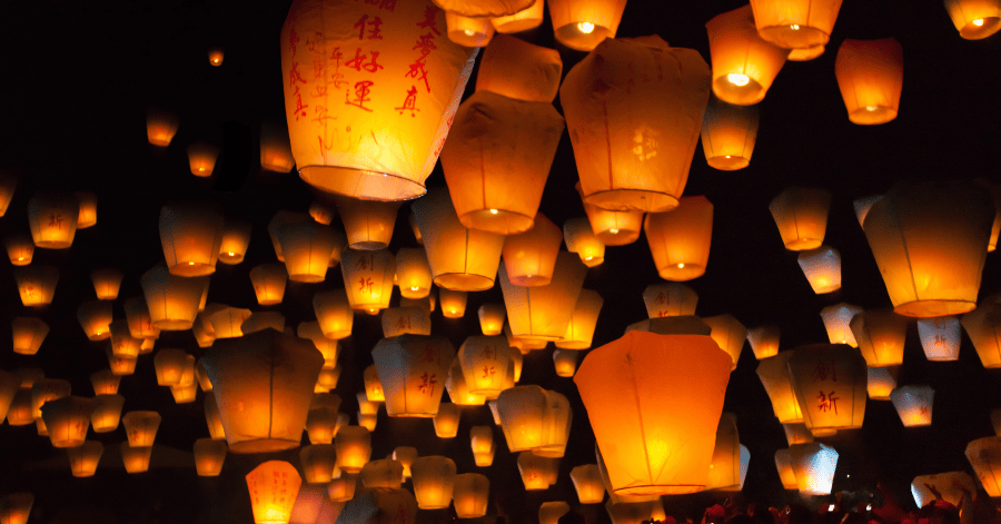 Glowing paper sky lanterns rising into the night sky at Taiwan's Pingxi Sky Lantern Festival