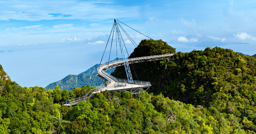 The curved Langkawi Sky Bridge suspended over forested hills with the sea beyond