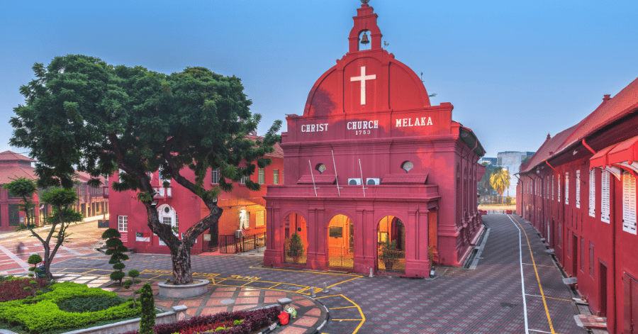 The red Christ Church and Dutch Square in Malacca beneath a shady tree