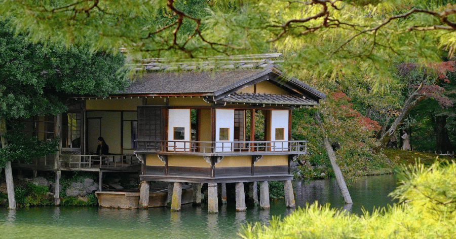 Traditional wooden teahouse on stilts over a garden pond in Kanazawa