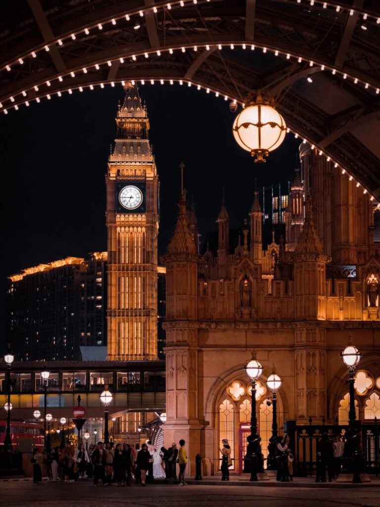 The Londoner Macau's lit Big Ben clock-tower replica at night framed by a fairy-light arch