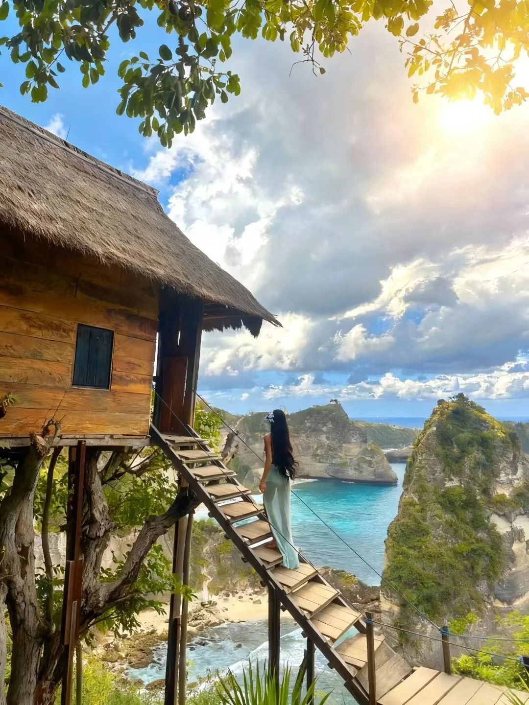 A visitor on the Rumah Pohon tree house ladder above the Thousand Islands bay at golden hour