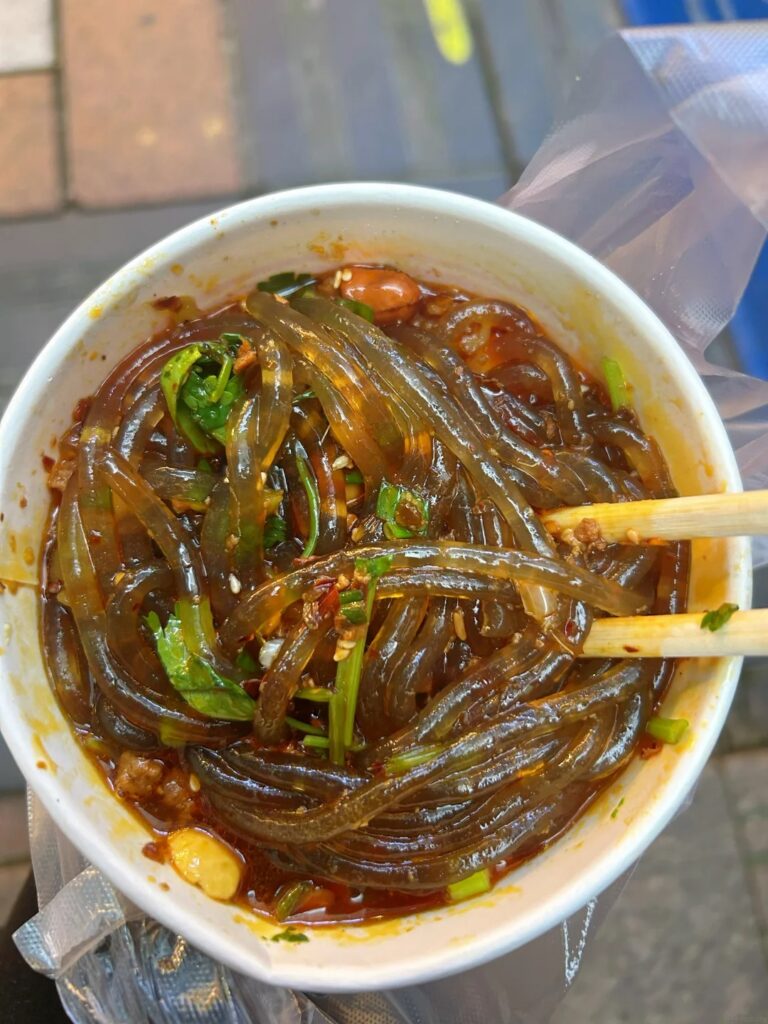 A cup of glassy suan la fen hot-and-sour sweet potato noodles, Chongqing