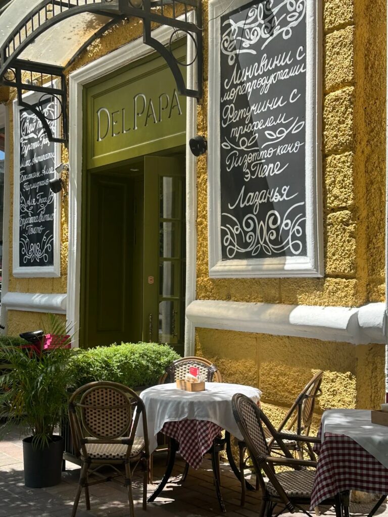 Outdoor cafe terrace with chalkboard menus on Almaty's pedestrian Arbat