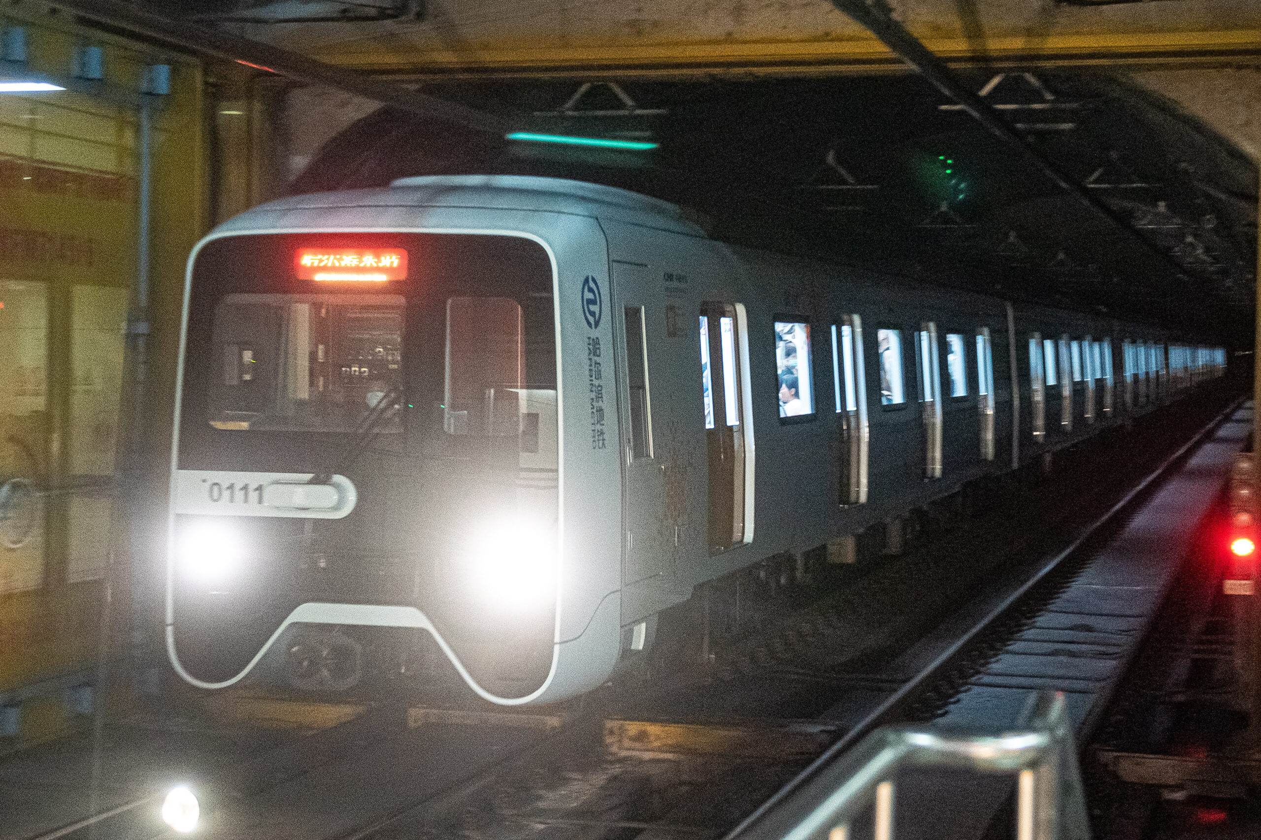 A Harbin Metro train arriving on the tracks at a station