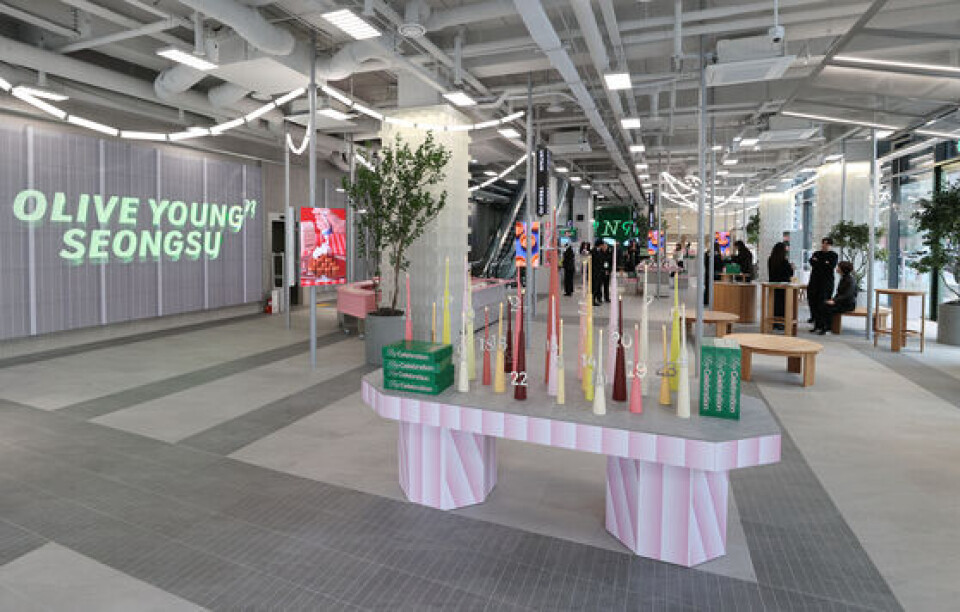 Olive Young Seongsu sign on a grey wall above a pastel display table in the store atrium