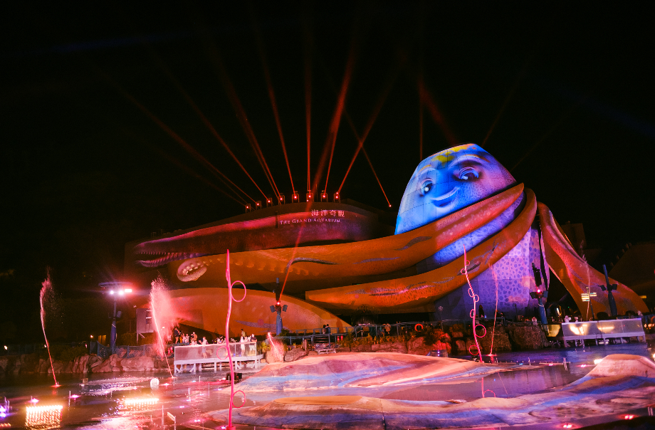 The Grand Aquarium lit with projection mapping and fountains during Ocean Park's nighttime show