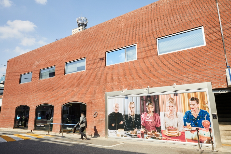 Red brick warehouse building on a Seongsu street with a large pop-up advertising hoarding