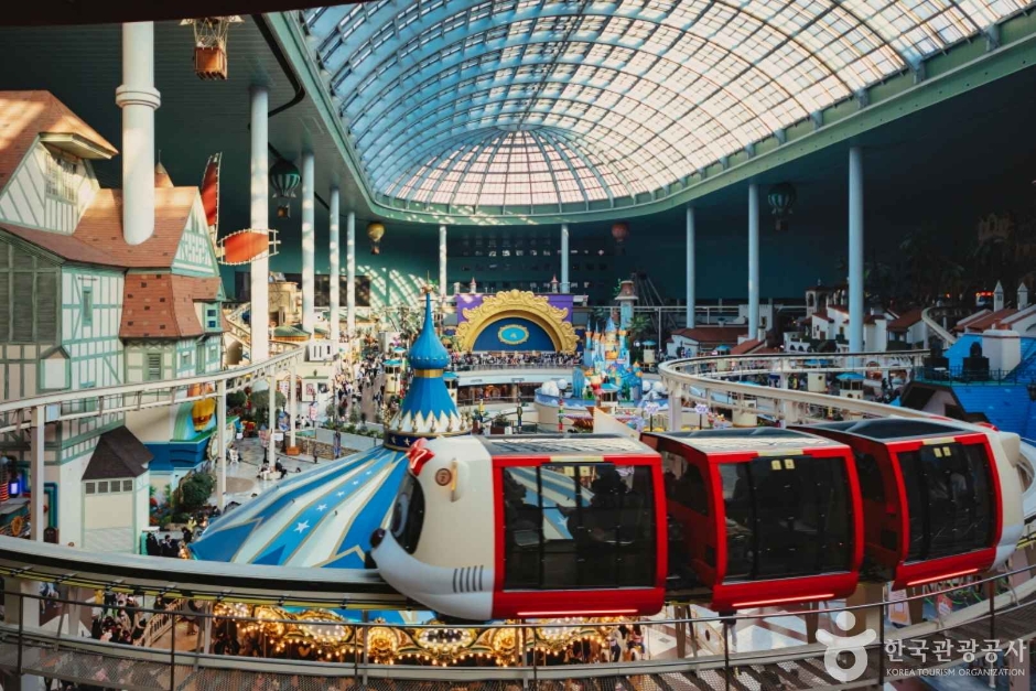 Lotte World's glass-roofed indoor dome with its monorail passing above the shops below