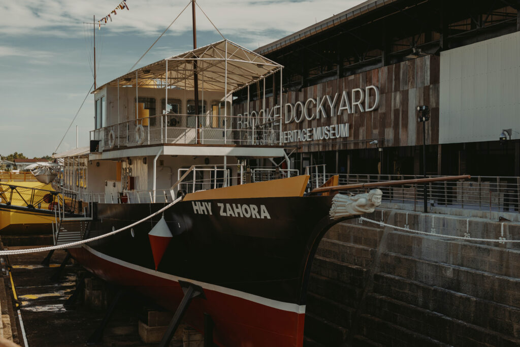 Replica vessel HHY Zahora in a dry dock beside the Brooke Dockyard Heritage Museum building