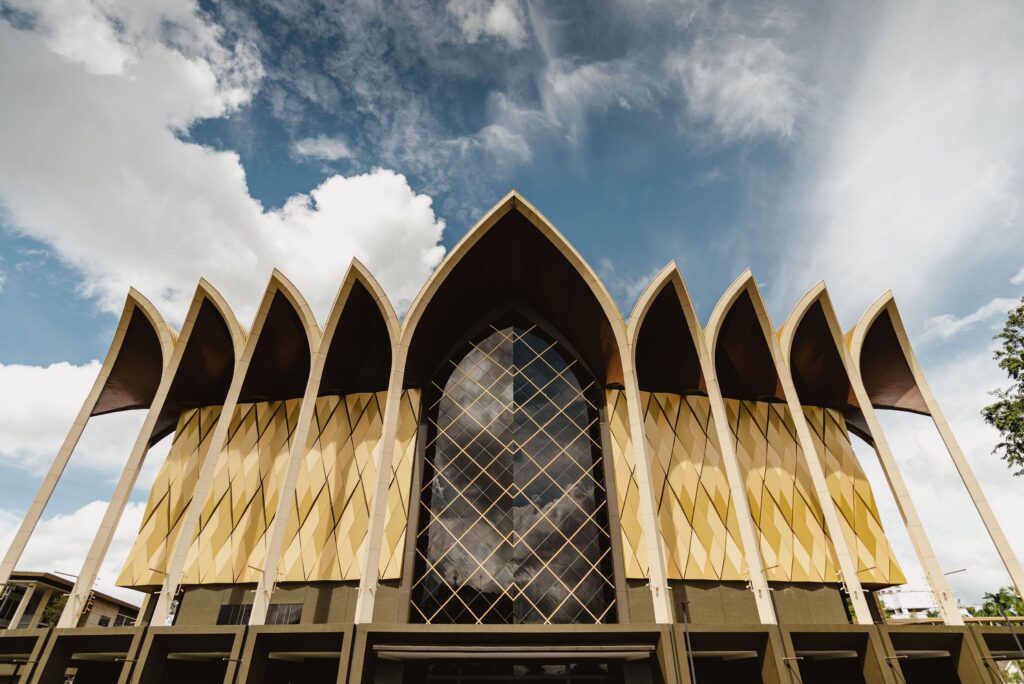 Row of tall pointed arches and gold panelling on the Borneo Cultures Museum exterior