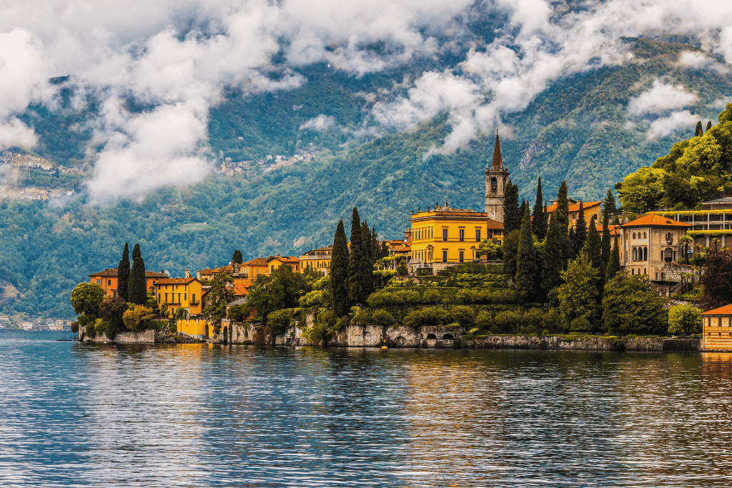 A lakeside village with pastel villas and cypress trees on the shore of Lake Como