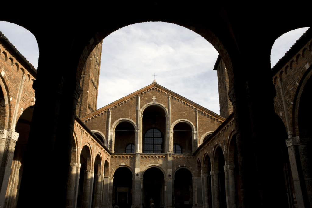 Romanesque brick facade of the Basilica di Sant'Ambrogio seen through its atrium arches, Milan