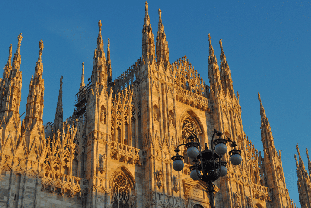 Milan's Gothic Duomo cathedral facade and spires glowing at golden hour