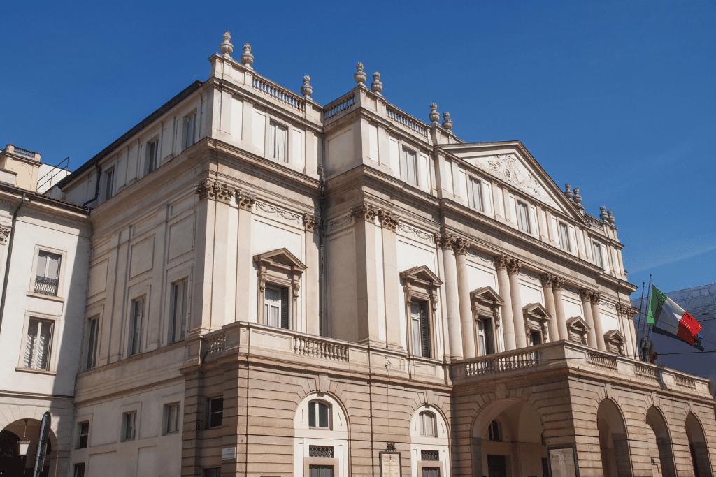The neoclassical stone facade of the Teatro alla Scala opera house in Milan