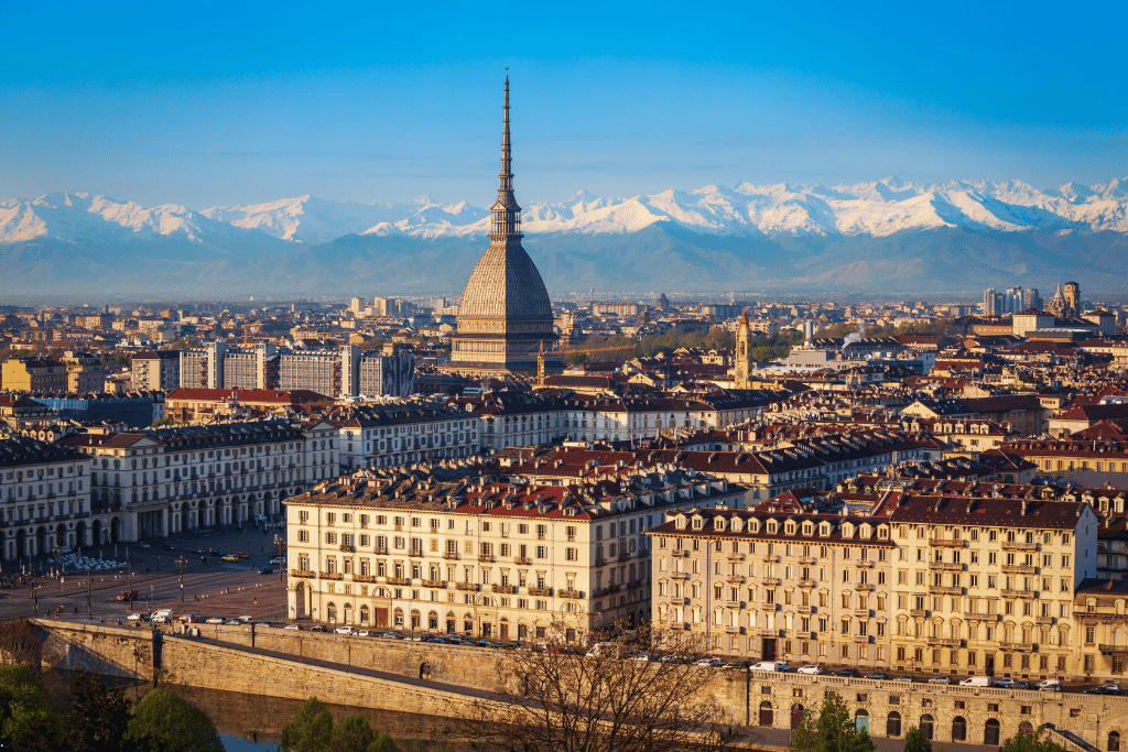 Turin's Mole Antonelliana rising above the rooftops with snow-capped Alps behind