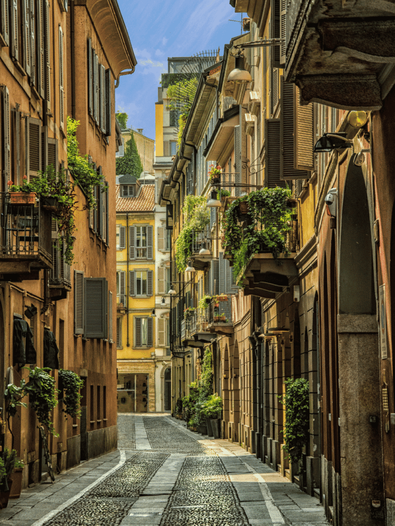 A quiet cobbled lane with plant-filled balconies in Milan's Brera district