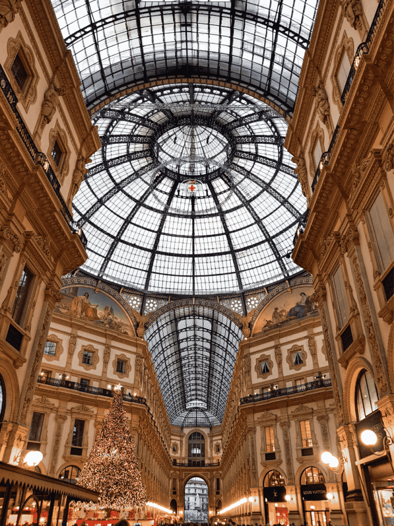 Glass-domed interior of the Galleria Vittorio Emanuele II with a lit Christmas tree