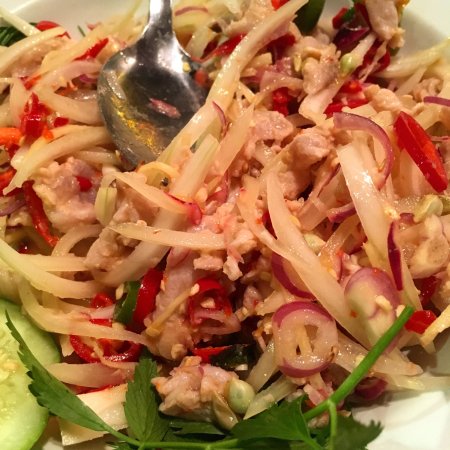 Umai raw fish salad tossed with sliced shallots, red chilli and lime on a white plate