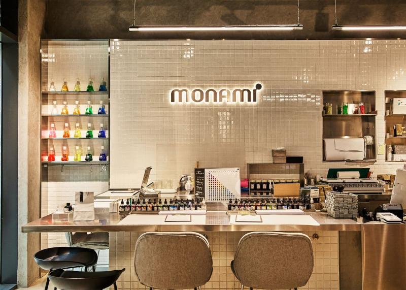 Monami sign above a tiled counter lined with ink bottles and pen parts