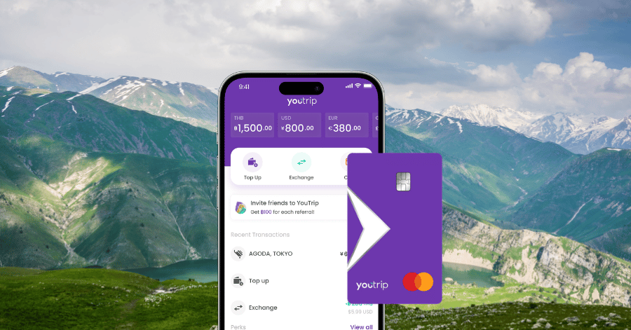 YouTrip app showing multi-currency balances beside a purple YouTrip Mastercard, mountains behind