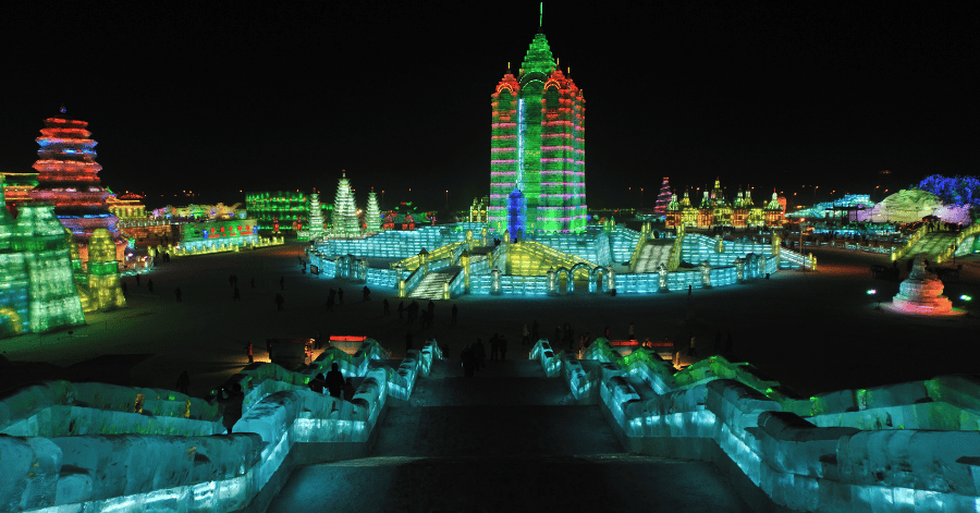 Harbin Ice and Snow World lit up at night, glowing ice towers in green, red and blue