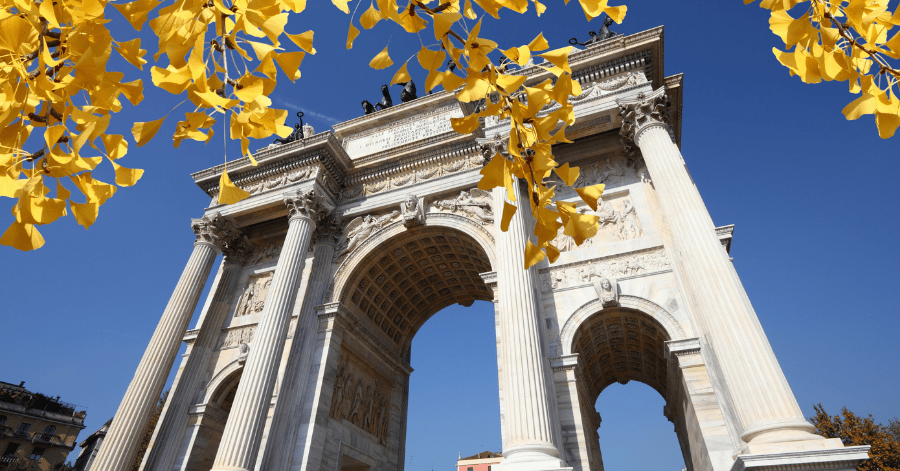 Milan's neoclassical Arco della Pace framed by golden autumn ginkgo leaves