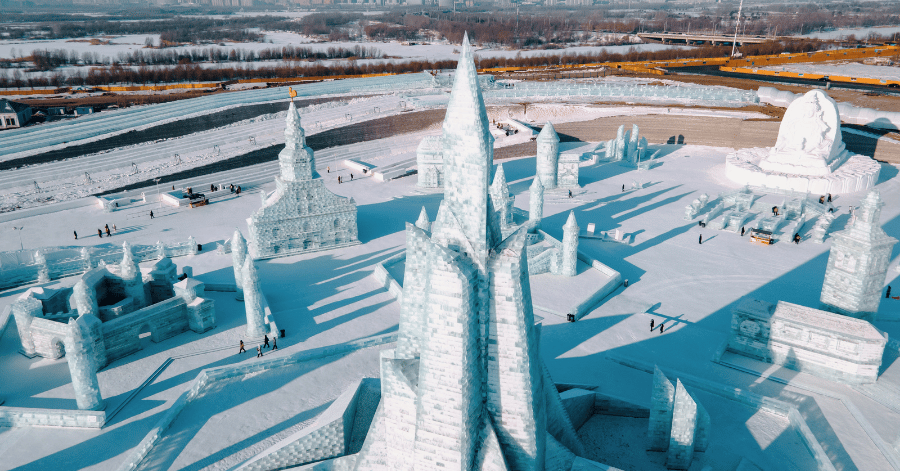 Aerial view of intricate ice sculptures and towers across a snow-covered festival ground