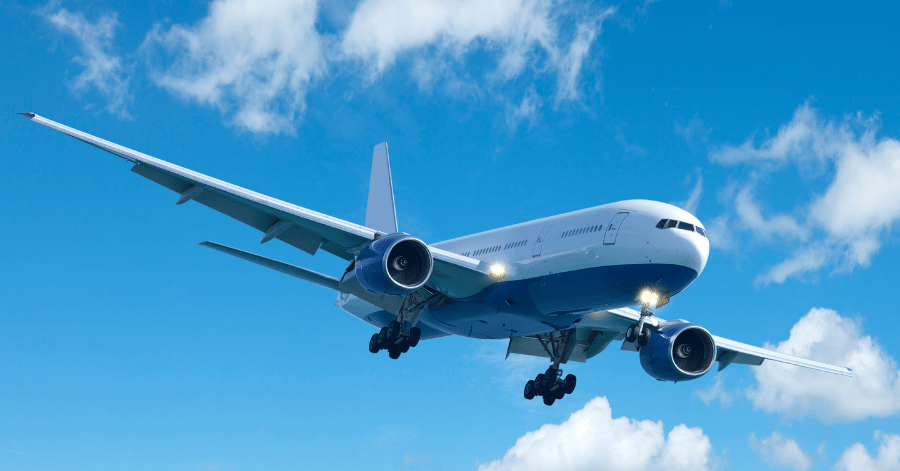 Passenger aircraft flying against a blue sky with scattered white cloud
